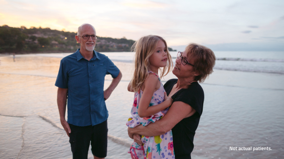 Grandfather, grandmother and granddaughter at the shore